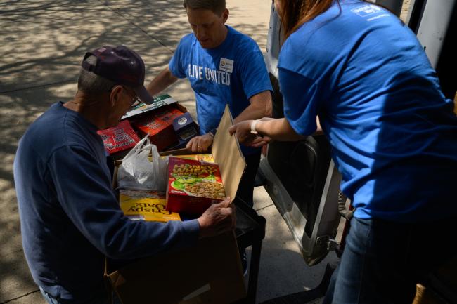 People delivering food items to a local pantry